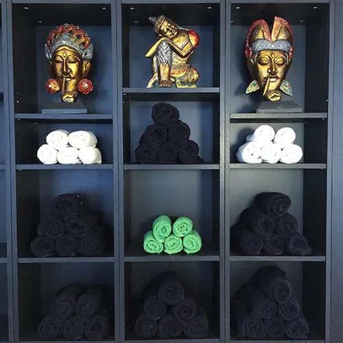 Regal mit Handtüchern und goldenen Masken