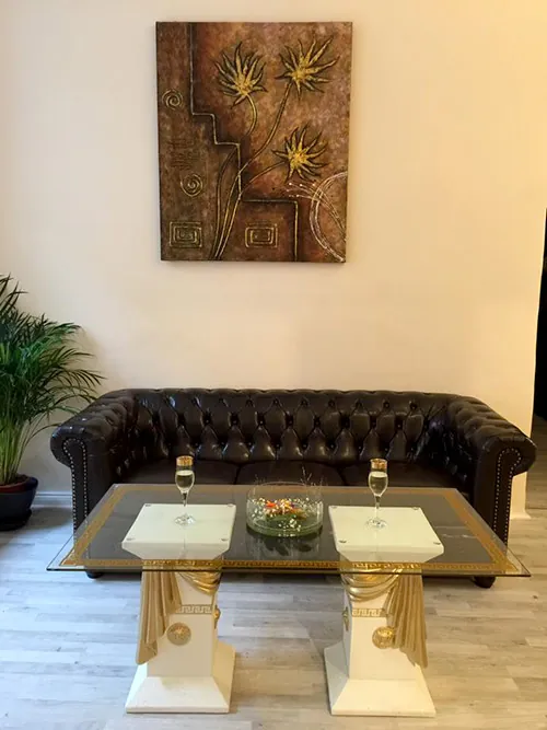 Lounge mit Chesterfield-Sofa und goldenem Tisch